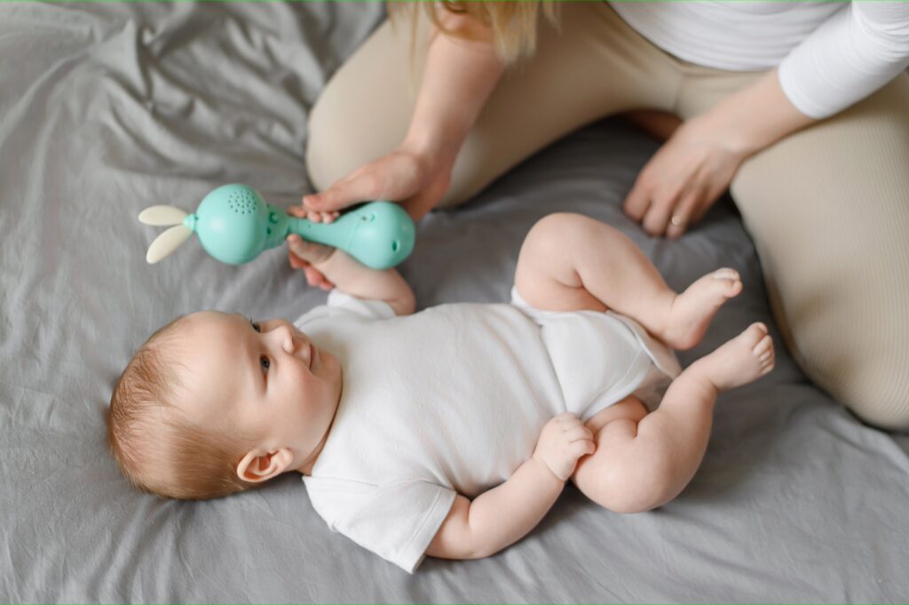 Cute,Baby,Is,Lying,On,Bed,,Babbling.,Mom,Gives,Baby